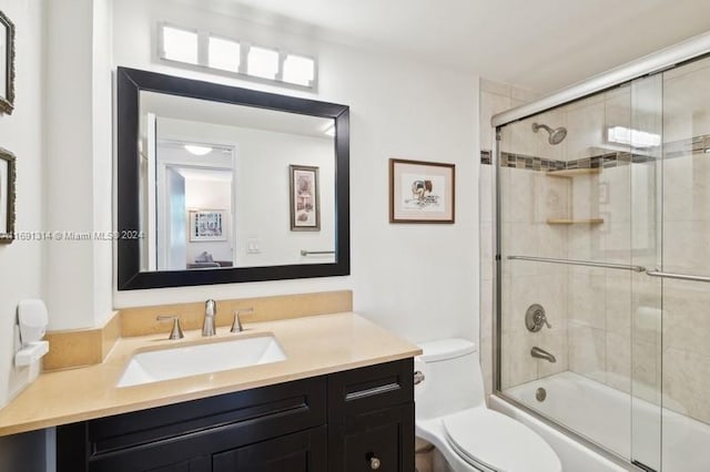 full bathroom featuring shower / bath combination with glass door, toilet, and vanity