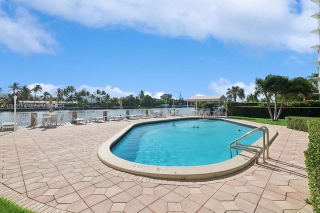 view of swimming pool with a water view and a patio area