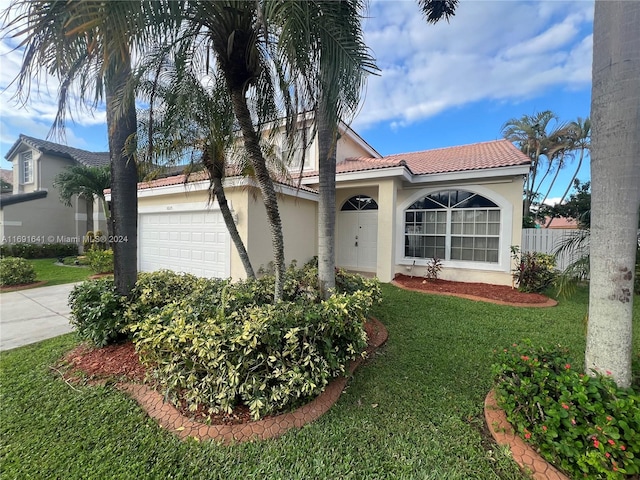 mediterranean / spanish-style house featuring a garage and a front lawn