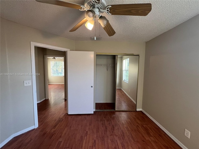 unfurnished bedroom featuring ceiling fan, dark hardwood / wood-style floors, a closet, and a textured ceiling