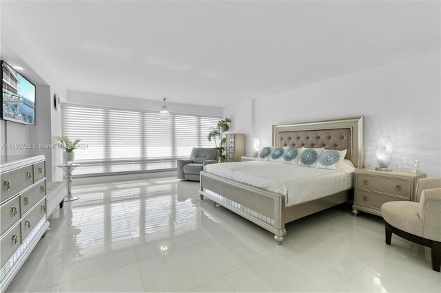 bedroom with a notable chandelier and light tile patterned floors