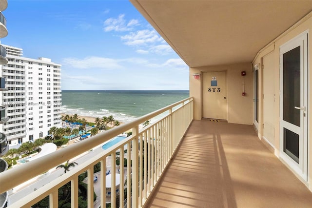 balcony featuring a beach view and a water view