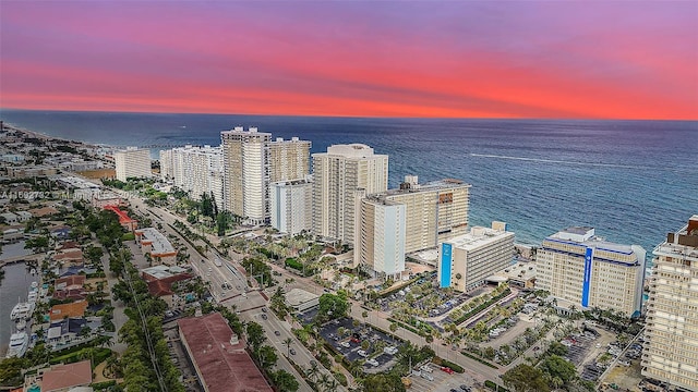 aerial view at dusk featuring a water view