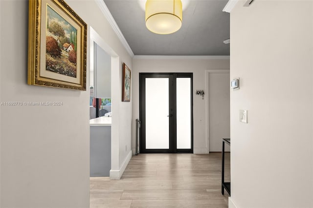 hall with light wood-type flooring, french doors, and ornamental molding