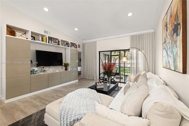 living room with light hardwood / wood-style floors, lofted ceiling, and ornamental molding