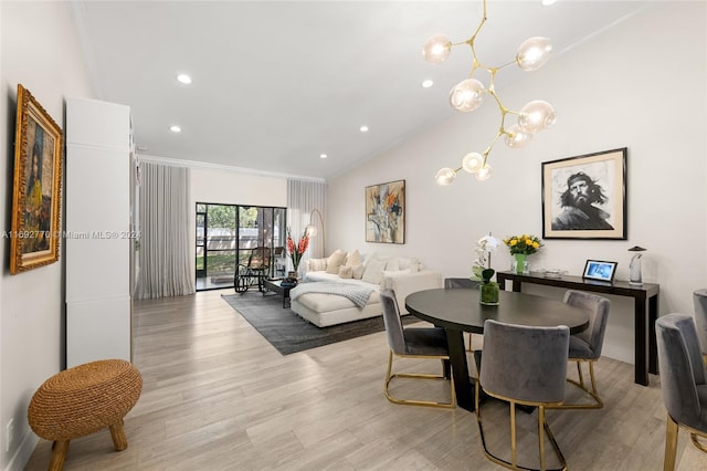 dining area featuring vaulted ceiling, a notable chandelier, crown molding, and light hardwood / wood-style flooring