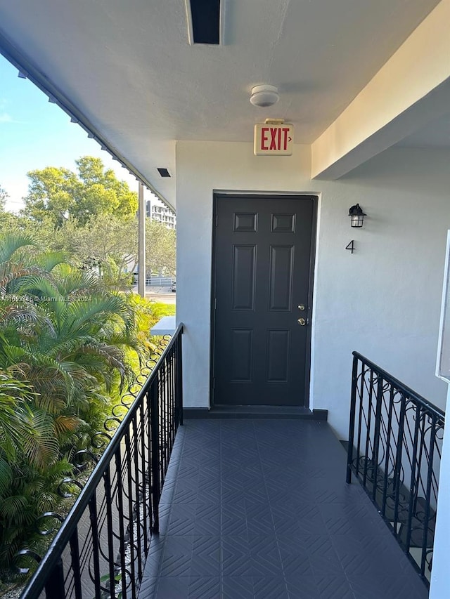 view of exterior entry featuring a balcony