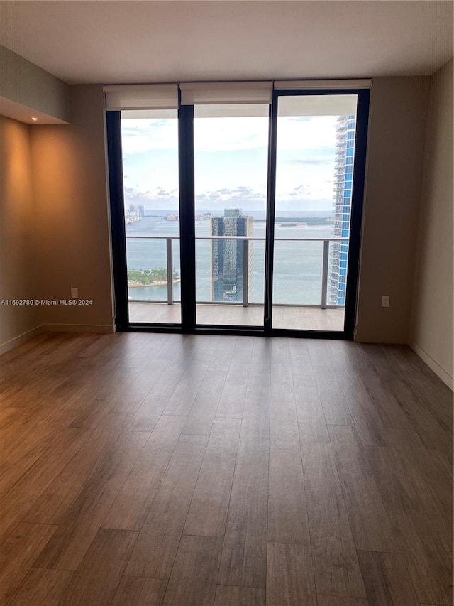 empty room featuring hardwood / wood-style floors and a water view