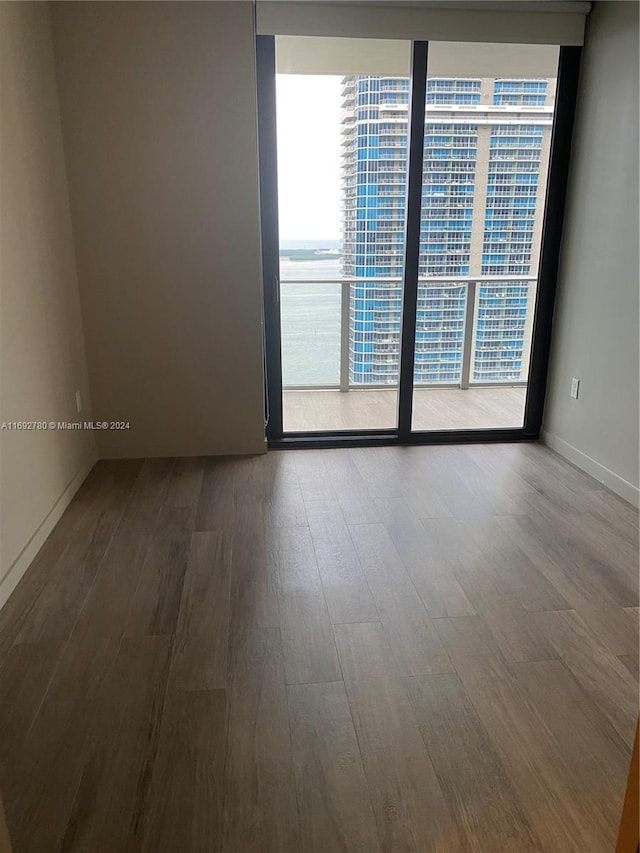 empty room featuring hardwood / wood-style flooring and a water view