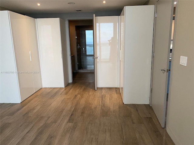 hallway with hardwood / wood-style floors