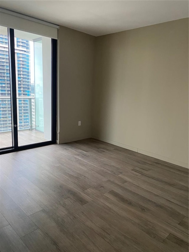 unfurnished room featuring wood-type flooring and floor to ceiling windows