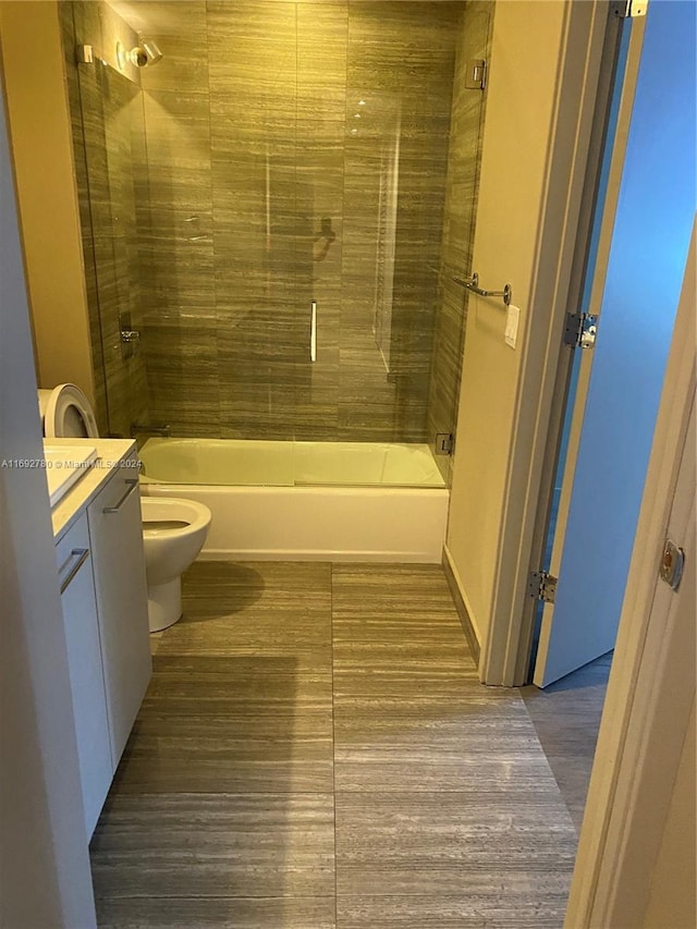 full bathroom featuring toilet, vanity, hardwood / wood-style floors, and tiled shower / bath