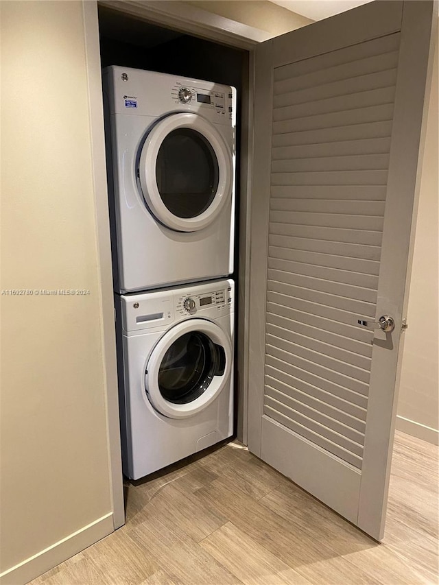 washroom featuring light hardwood / wood-style flooring and stacked washer / drying machine