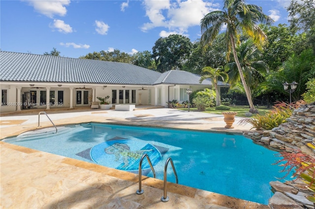 outdoor pool with french doors, a patio, and ceiling fan