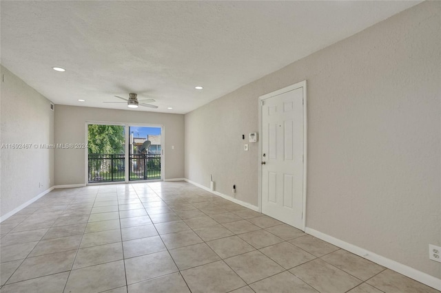 tiled empty room featuring a textured ceiling and ceiling fan