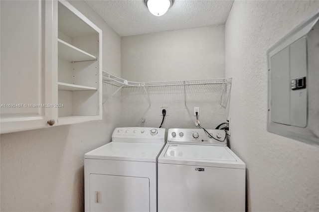 washroom with electric panel, washing machine and dryer, and a textured ceiling