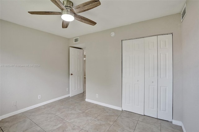 unfurnished bedroom with a closet, light tile patterned floors, and ceiling fan