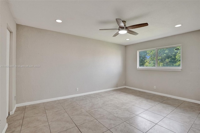 tiled spare room featuring ceiling fan