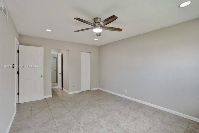 tiled empty room featuring ceiling fan