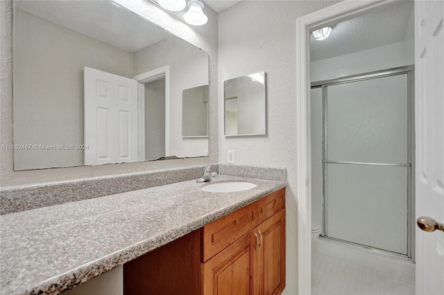 bathroom featuring an enclosed shower and vanity