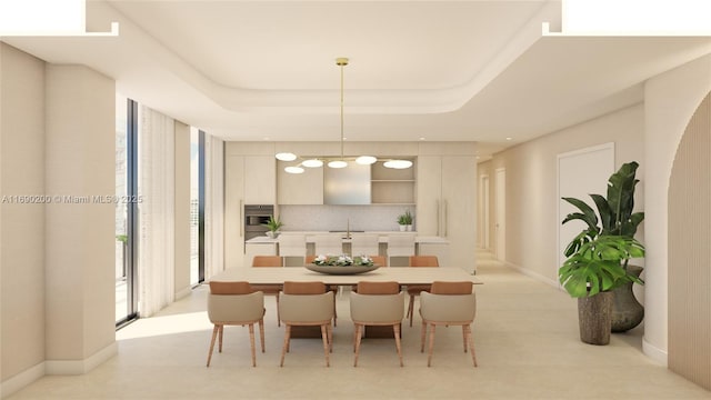 dining area with baseboards and a raised ceiling