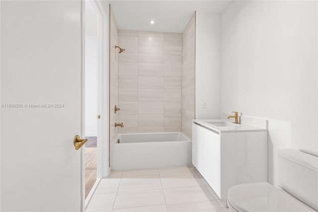 full bathroom with tile patterned flooring, vanity, tiled shower / bath combo, and toilet