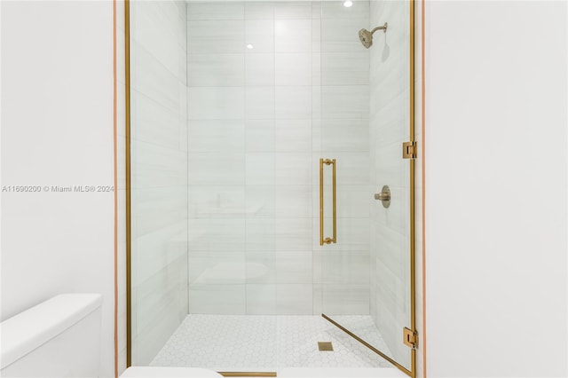 bathroom featuring an enclosed shower and toilet