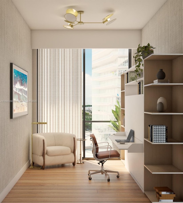 office area with wallpapered walls and hardwood / wood-style floors