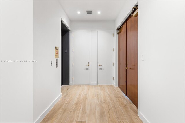 hall featuring a barn door and light wood-type flooring