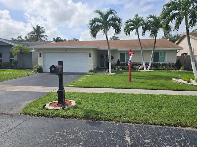 single story home featuring a front lawn and a garage