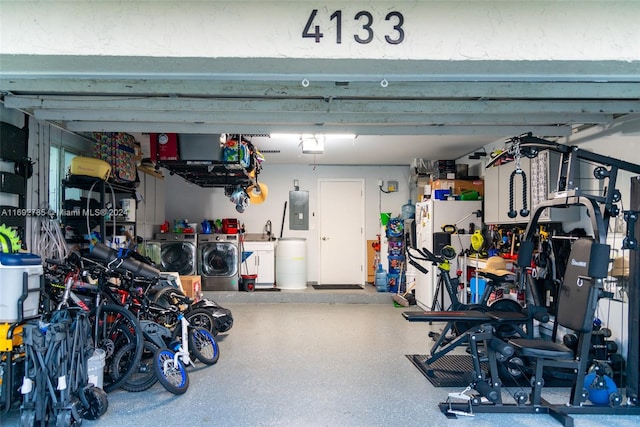 garage with electric panel and washer and clothes dryer