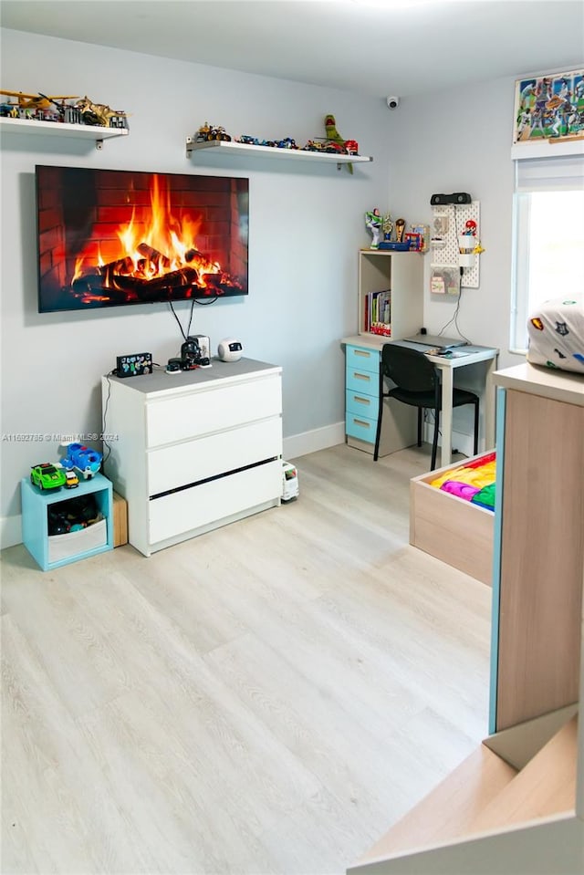 bedroom featuring light hardwood / wood-style floors and a fireplace