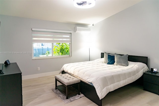 bedroom featuring light hardwood / wood-style floors and a wall mounted air conditioner