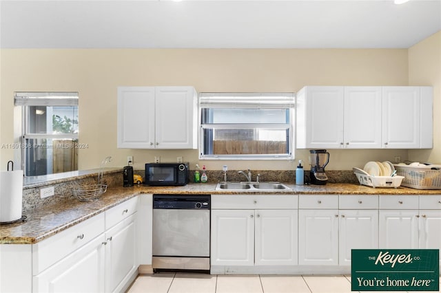 kitchen featuring dishwasher, white cabinets, sink, light tile patterned floors, and stone countertops