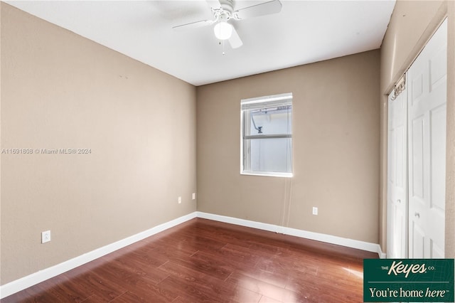 unfurnished bedroom featuring a closet, dark hardwood / wood-style floors, and ceiling fan