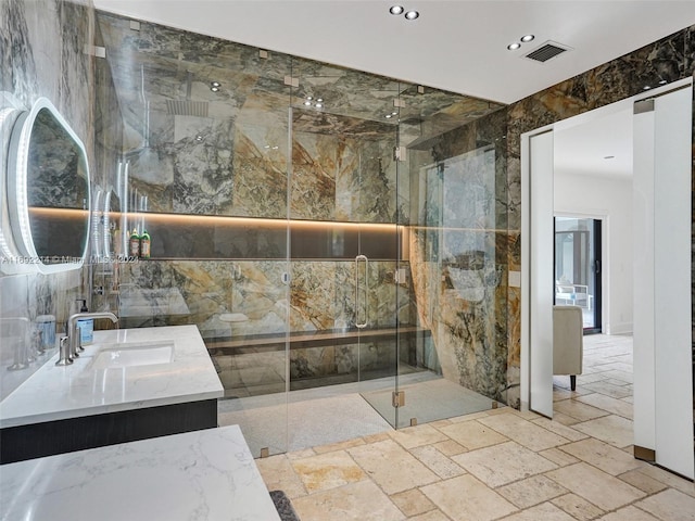 bathroom featuring vanity, tile walls, and a shower with shower door