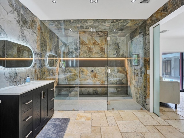 bathroom with an enclosed shower, vanity, and tile walls