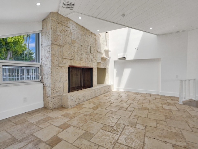 unfurnished living room with a large fireplace and lofted ceiling