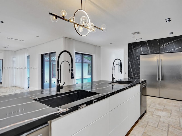 kitchen with white cabinets, pendant lighting, sink, and stainless steel appliances