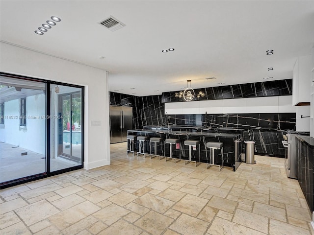 kitchen with decorative backsplash, a kitchen bar, tile walls, and appliances with stainless steel finishes