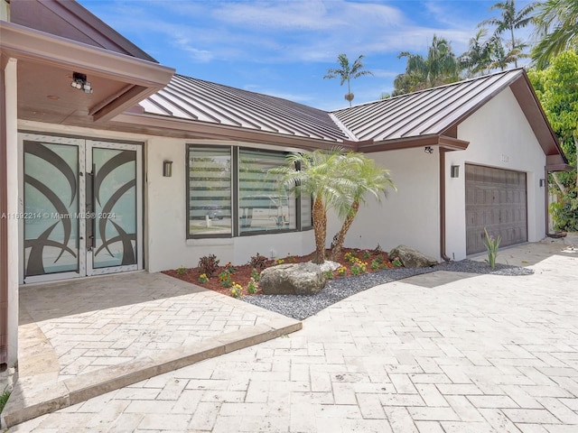 property entrance featuring a garage and french doors