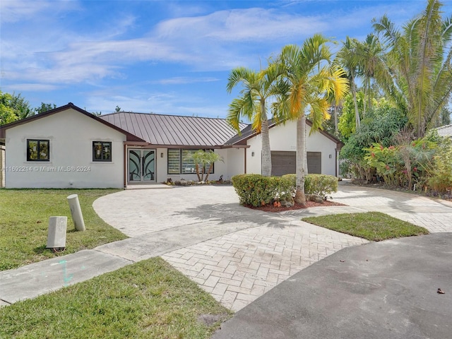 ranch-style home featuring a garage and a front lawn