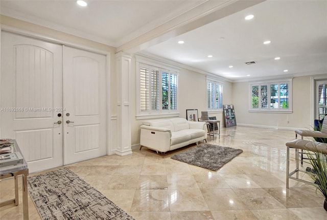 entryway with plenty of natural light and ornamental molding