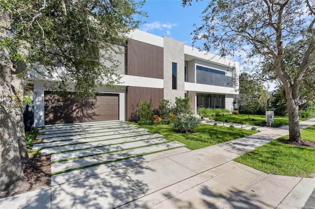 modern home featuring a front yard and a garage