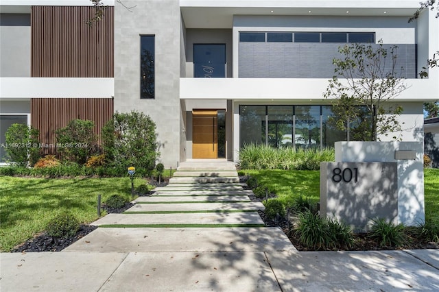 entrance to property with a lawn