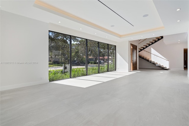 unfurnished living room with a tray ceiling