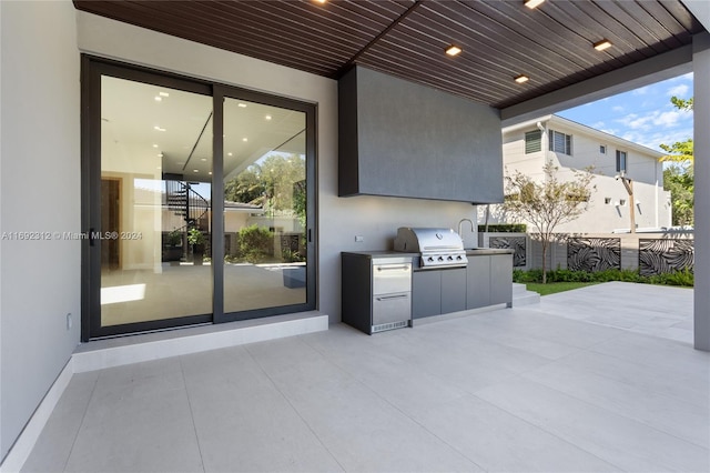 view of patio with an outdoor kitchen, sink, and grilling area