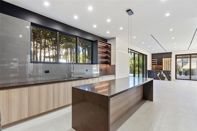 bar with backsplash, sink, decorative light fixtures, and light brown cabinets