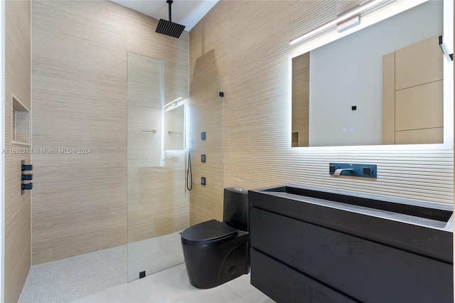 bathroom featuring toilet, vanity, tile walls, and tiled shower