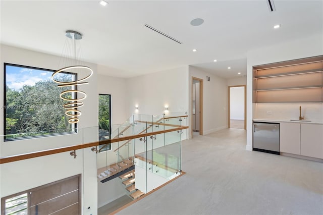 hallway with a notable chandelier and sink